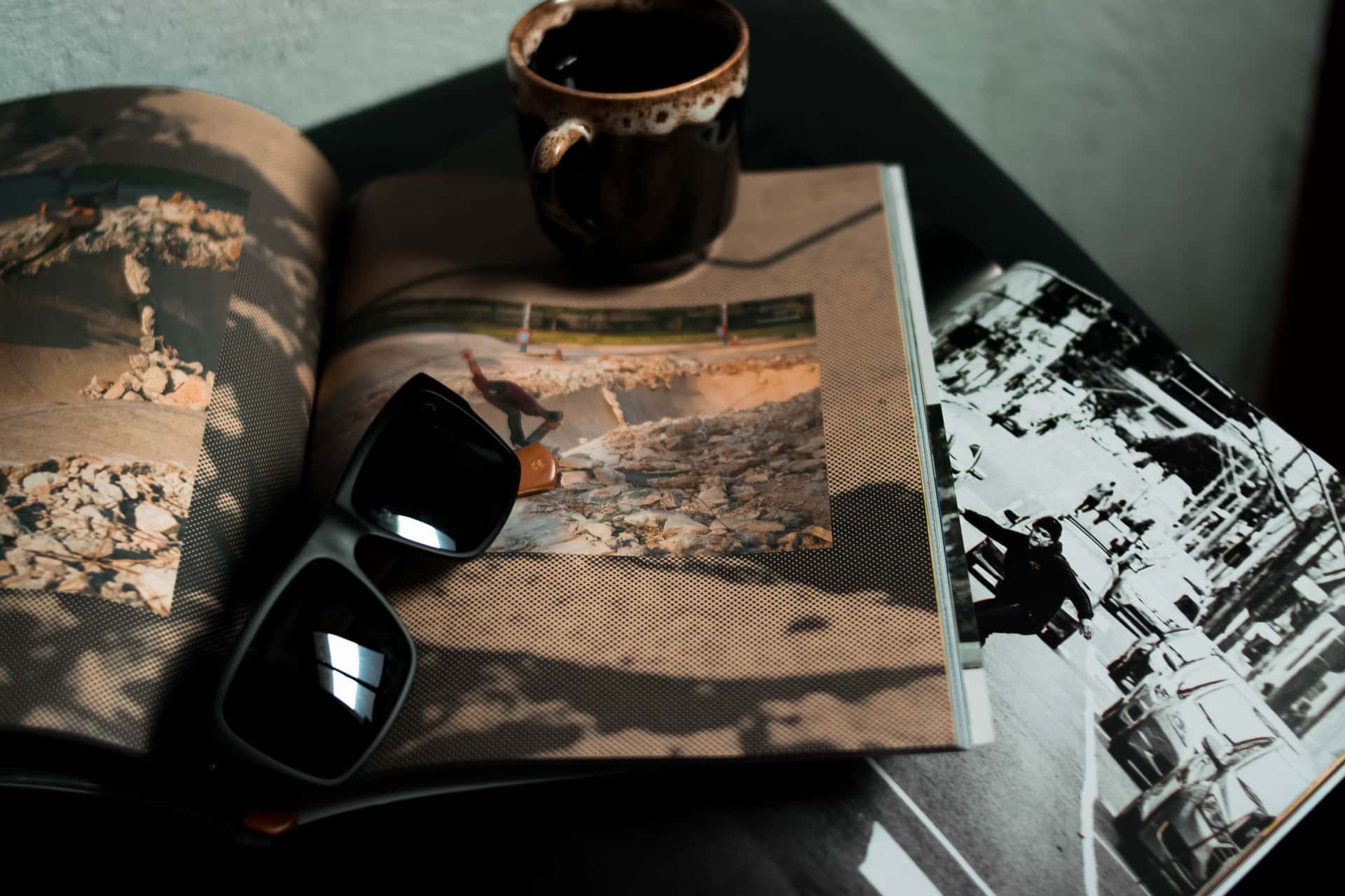 Sunglasses resting on an open notebook beside a warm coffee, a buying-guide still life