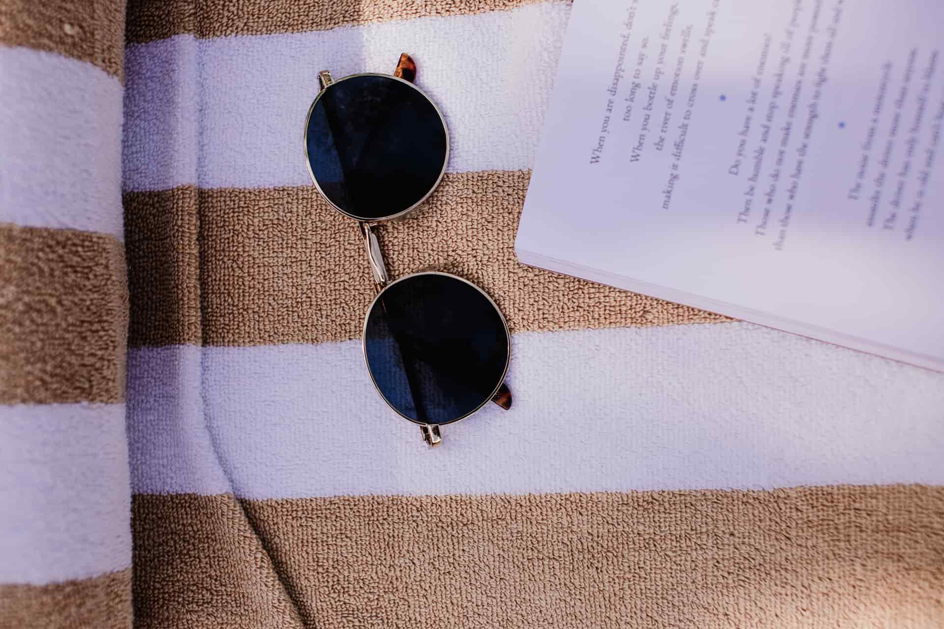 Round acetate sunglasses laid flat on a cream background